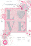 The anniversary card pictured here is a tender tribute to lasting romance, blending delicate hues of pastel pink, soft grey, and pearly white in a way that recalls an English spring garden tucked behind the busy streets of Walworth. At its centre, the word LOVE appears in raised, gently contoured letters, each one coated in soft, shimmering glitter that looks smooth yet textured to the touch. The O takes the form of a radiant heart shape, richly filled with silver sparkle that stands out like a cherished pendant nestled among petals. Around this central word, an arrangement of illustrated flowers unfolds in shades of blush and mauve, their edges feathered like watercolour washes. Slender stems, flowing curves, and tiny buds weave together, creating a sense of motion and tenderness. Here and there, miniature butterflies and swirling flourishes add a hint of whimsy, suggesting the joyful flutter of shared moments and memories. The background remains a warm, understated pink, acting as a soft canvas that enhances the floral design rather than competing with it. Above or below the main motif, phrases such as On Our Anniversary and I love you today and always are scripted in an elegant, flowing hand, giving the card a personal, handwritten feel. The overall composition is calm, intimate, and deeply affectionate-an ideal keepsake to accompany a bouquet delivered to a doorstep near Walworth Road or by the gardens of Pasley Park, marking another year of love that is quiet yet profoundly felt.